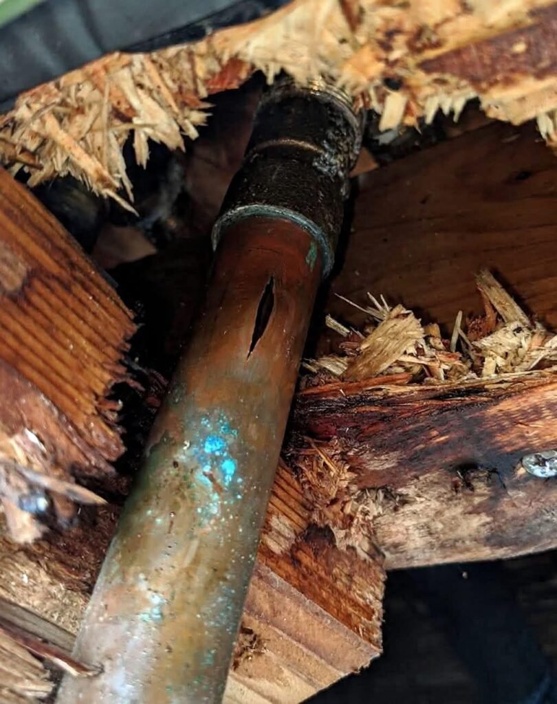 Burst copper pipe leaking inside attic causing water damage to wood framing and insulation
