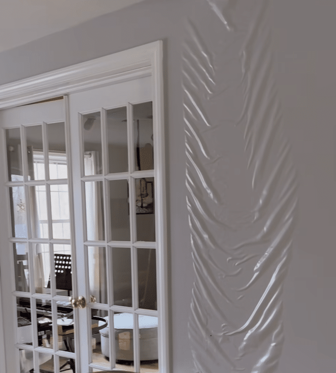 Severe water damage causing wall bulging and ceiling leak inside a home in Charlotte NC