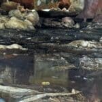 Standing water and damaged insulation visible.