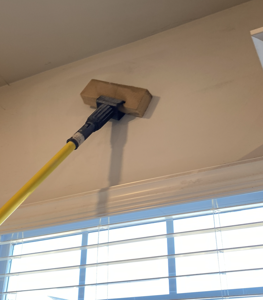 Technician cleaning smoke and soot damage from walls after fire in Charlotte NC