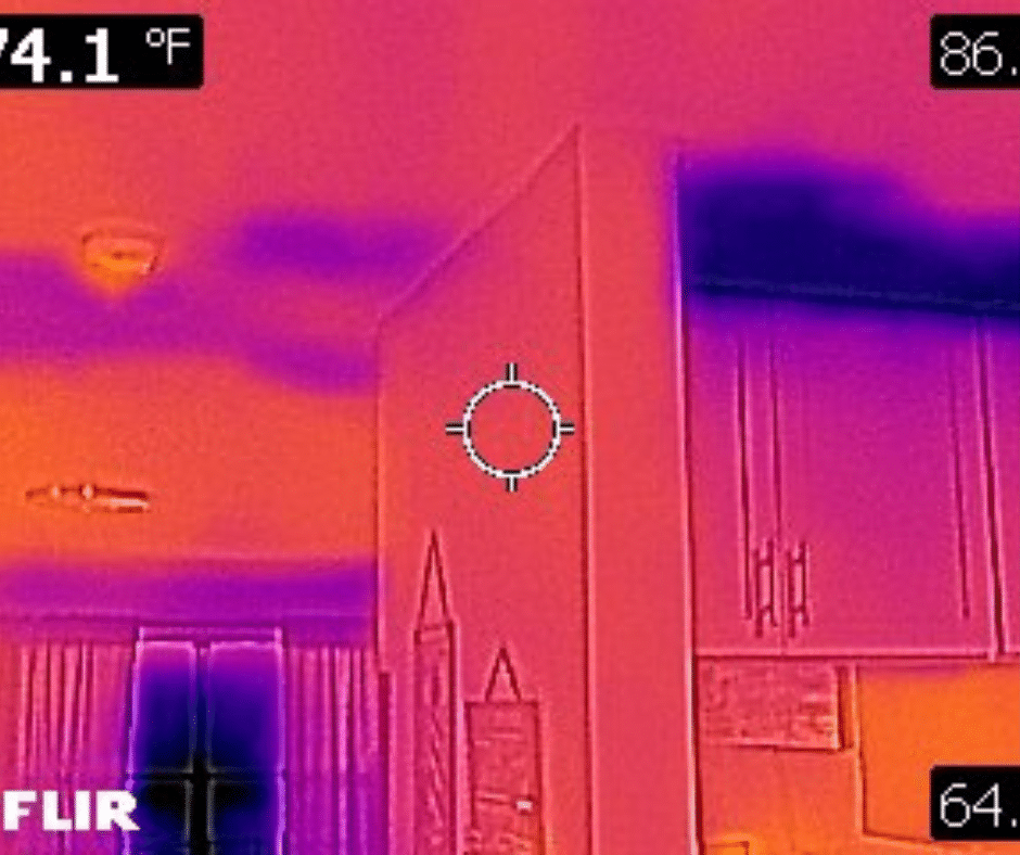 Thermal imaging scan of an interior wall and kitchen area showing temperature differences, with cooler dark purple areas near the ceiling and cabinets indicating possible hidden moisture or water intrusion.